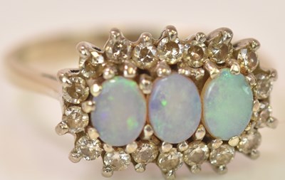 Lot 590 - A white metal opal and diamond cluster ring...