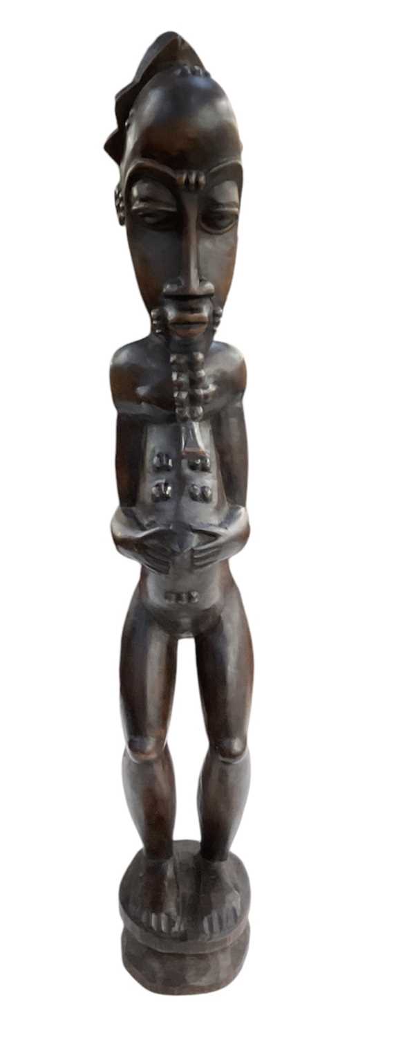 Lot 1095 - A tall African carved wooden Baule figure,...