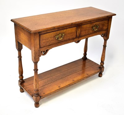 Lot 90 - A reproduction oak side table in the manner of...