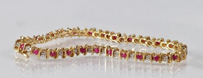 Lot 864 - A 9ct yellow gold ruby and diamond set...