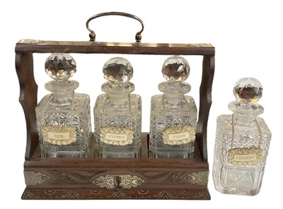 Lot 343 - An early 20th century oak tantalus with silver...