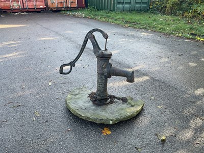 Lot 270 - A cast iron water pump, bolted to a stone flag,...