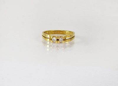 Lot 831 - An 18ct yellow gold ring set with two diamonds,...