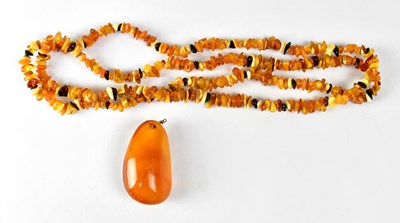 Lot 913 - An amber-coloured pendant with clouded upper...