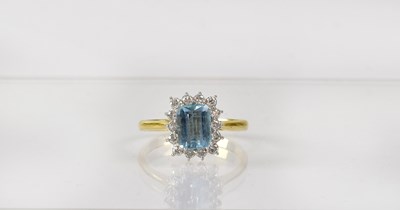 Lot 825 - An 18ct gold cluster ring set with emerald cut...