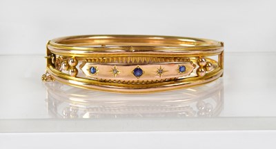 Lot 860 - A 9ct gold bangle with double reeded band set...