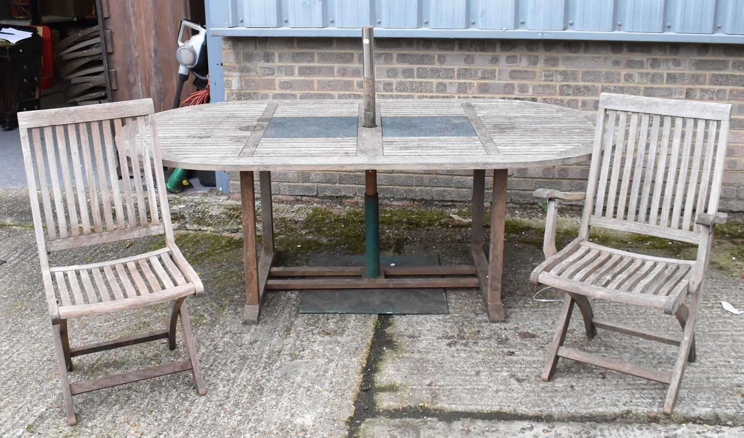Lot 408 A large oval garden table and set of eight