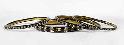 Lot 941 - CHANEL; a black resin bangle set with diamanté...