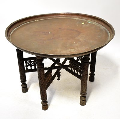 Lot 60 - A Middle Eastern copper tray-top table with...