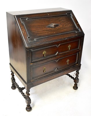 Lot 27 - A 1930s oak bureau with moulded decoration,...