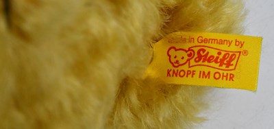 Lot 350 - STEIFF; a golden bear wearing green scarf and...