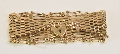 Lot 540 - A broad 9ct yellow gold gate link bracelet,...