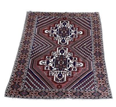 Lot 93 - A red ground rug, with geometric designs, 200...