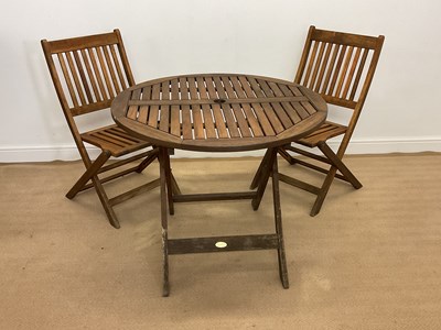 Lot 719 - A teak folding garden table and two matching...