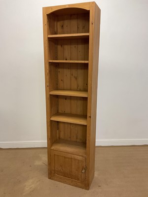 Lot 799 - A narrow pine bookcase with cupboard to the...