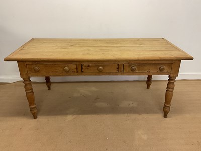 Lot 758 - A pine farmhouse kitchen table with three...