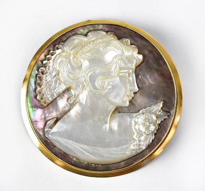 Lot 1076 - A circular carved abalone cameo pendant brooch...