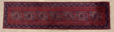 Lot 694 - A handmade Indian red and blue runner, 242 x 62cm