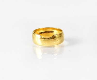 Lot 1059 - A 22ct yellow gold wedding band, with a...