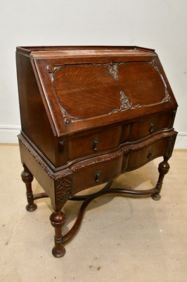 Lot 216 - A 1920s oak bureau, the carved fall front...