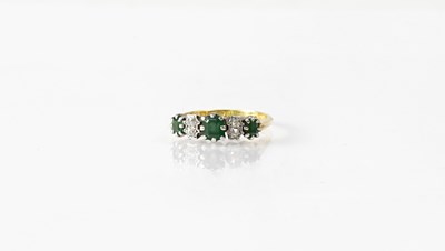 Lot 1063 - An 18ct yellow gold ring set with emeralds and...