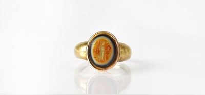 Lot 1070 - A yellow metal ring set with an oval carved...