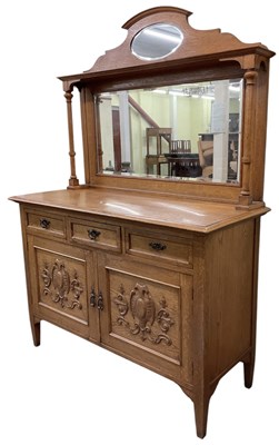 Lot 26 - An early 20th century light oak mirror back...