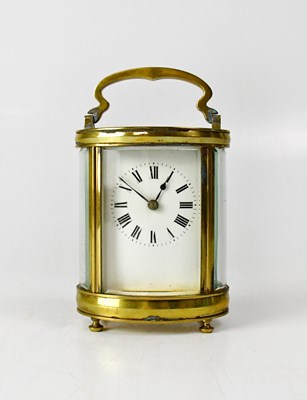 Lot 123 - A brass cased carriage clock in an oval case...