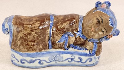 Lot 273 - A Chinese glazed earthenware pillow, modelled...