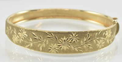 Lot 825 - A 9ct gold hinged bracelet, with floral bright...