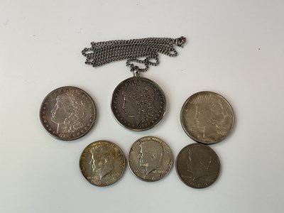 Lot 411 - An 1882 silver dollar on chain, 1924 dollar,...