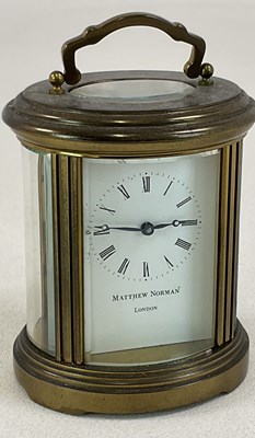 Lot 672 - MATTHEW NORMAN; an oval brass carriage clock,...