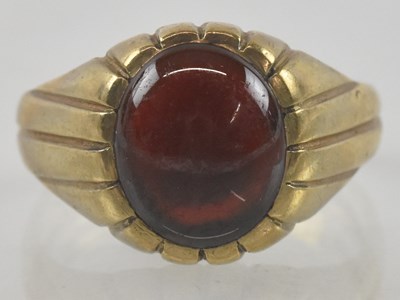 Lot 872 - A 9ct gold signet ring with an oval set red...