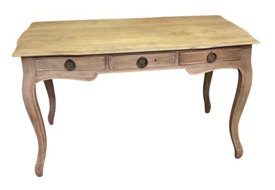 Lot 81 - A modern limed oak three drawer writing table...