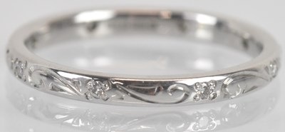 Lot 1285 - An 18ct white gold wedding band, with engraved...