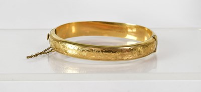 Lot 770 - A 9ct yellow gold hinged bangle with floral...