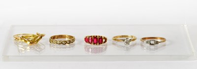 Lot 750 - An 18ct yellow gold ring set with red stones...