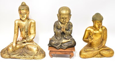 Lot 265 - Three carved wooden gold-coloured Buddha...