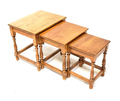 Lot 18 - An early 20th century oak nest of three tables,...