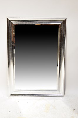 Lot 134 - A wall mirror with silver-coloured wooden...