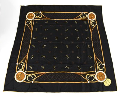 Lot 783 - GUCCI; a 100% silk black, tan and gold scarf...