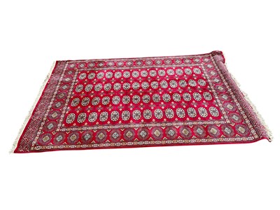 Lot 328 - A large Bokhara style red ground rug, with...