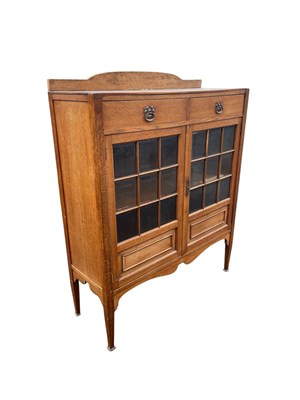 Lot 11 - An Arts and Crafts light oak bookcase with...