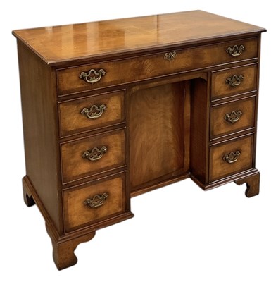 Lot 35 - A reproduction walnut kneehole desk, with...