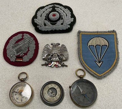 Lot 54 - Military badges and compasses, comprising a...