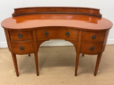 Lot 411 - An Edwardian satinwood kidney shaped kneehole...