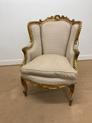 Lot 395 - A French gilt wood wingback upholstered...