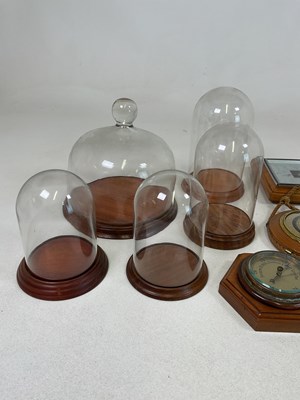 Lot 33 - A quantity of glass domes with wooden bases,...