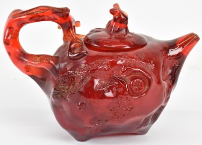 Lot 1005 - A Chinese carved amber teapot, the handle and...