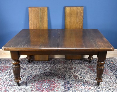Lot 2975 - An Edwardian oak extending dining table, with...